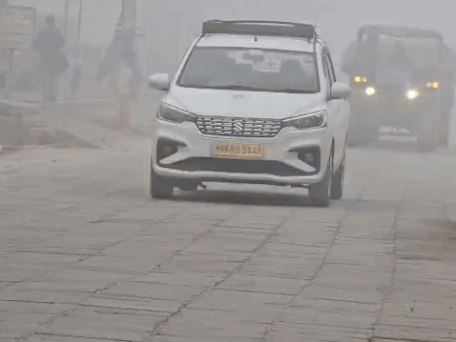 सोनीपत में धुंध के बीच गुजरते वाहन।