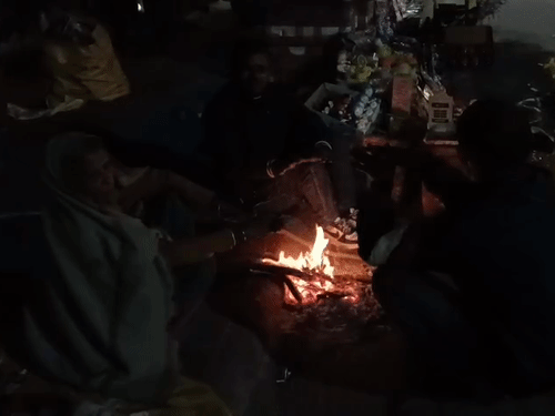 सर्दी से बचाव के लिए अलाव तापते लोग।