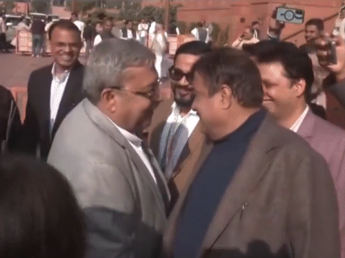 कल्याण गडकरी के कान में कुछ कहते हैं।