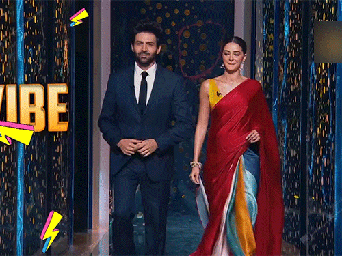 कार्तिक फॉर्मल सूट में और अनन्या लाल साड़ी में शो में पहुंचीं।