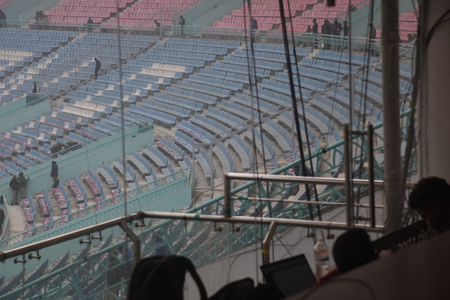 इकाना स्टेडियम में मैच शुरू होने से पहले सीटों पर धूल जमा थी।