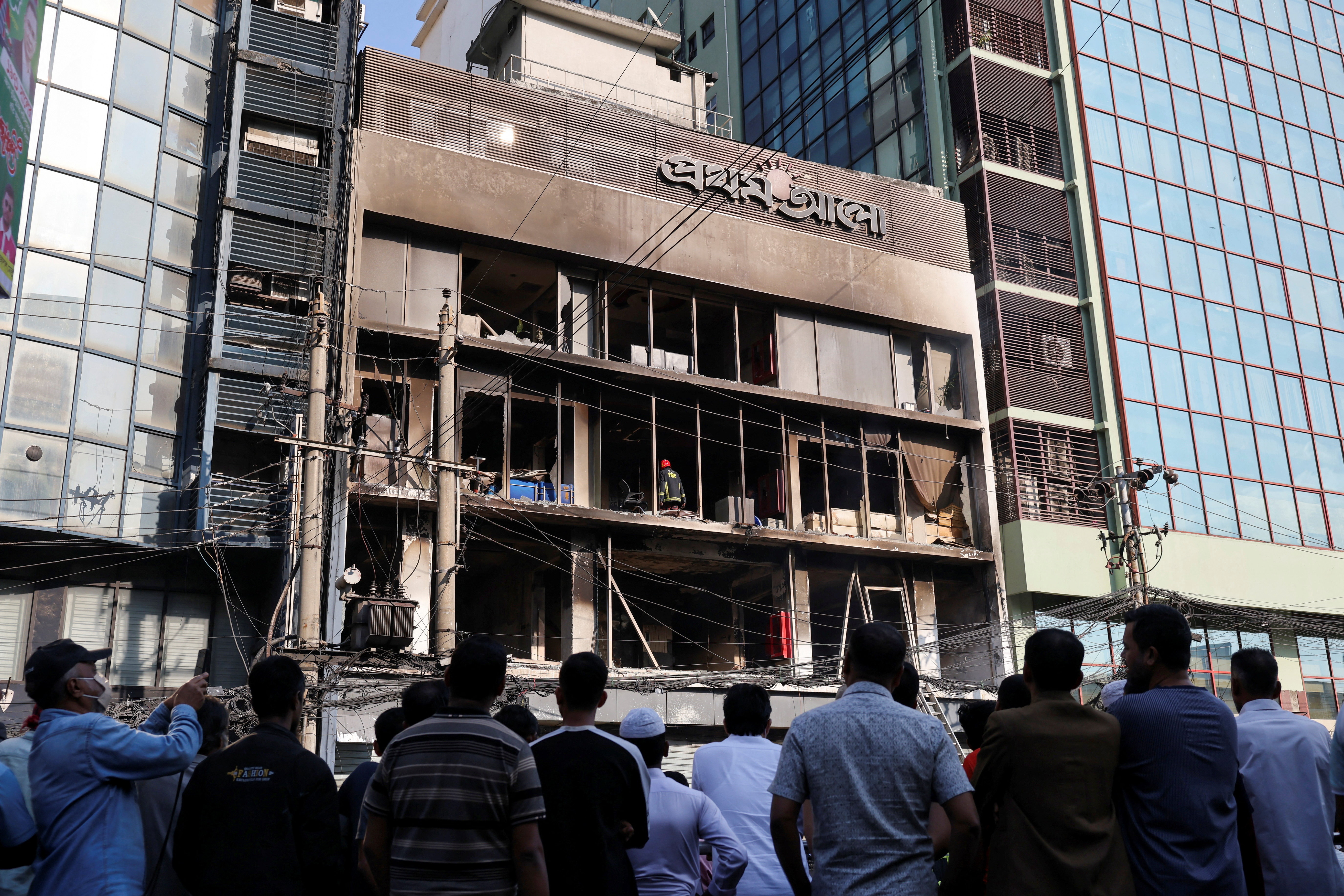 बांग्ला अखबार प्रथोम आलो के दफ्तर के बाहर शुक्रवार सुबह लोग जमा हैं।