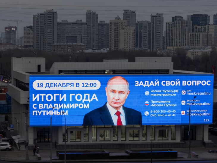रूस की राजधानी मॉस्को में 18 दिसंबर को एक इमारत के सामने लगी डिजिटल स्क्रीन पर रूसी राष्ट्रपति व्लादिमीर पुतिन के साल के अंत में होने वाले वार्षिक कार्यक्रम का प्रचार किया गया।