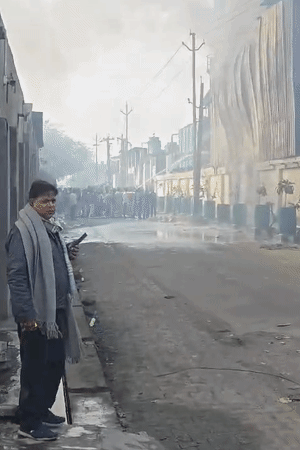 फैक्ट्री के बाहर से पानी की पाइप के जरिए आग बुझाते लोग।