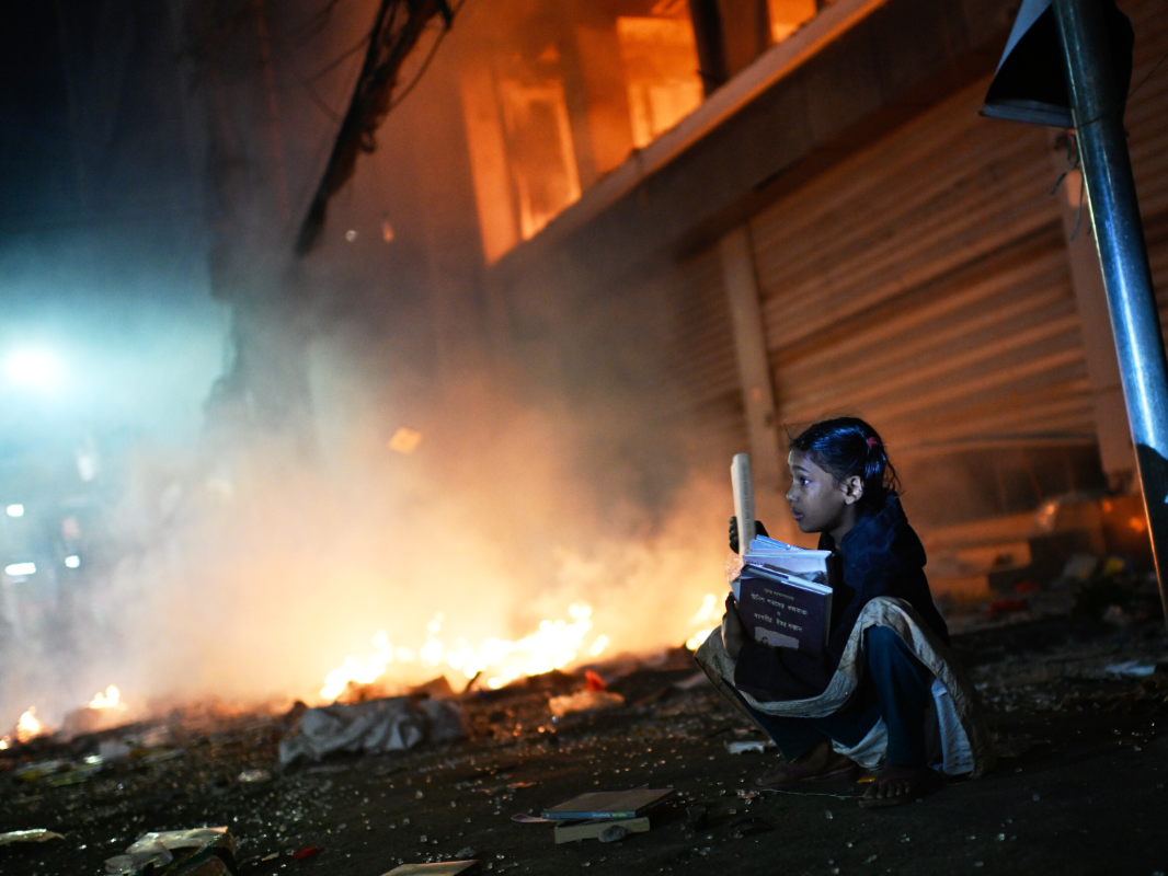 A shop near the premises of Prothom Alo Newspaper office was set on fire by the protesters. After this incident, a girl was seen saving books from the shop.