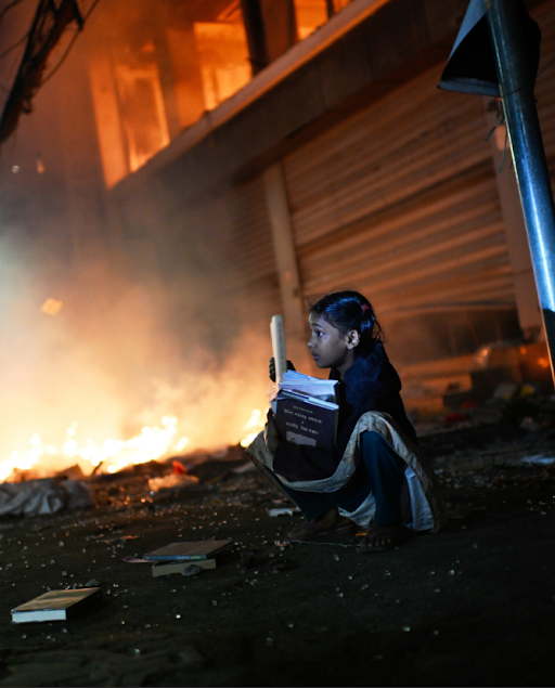 प्रोथोम आलो न्यूजपेपर ऑफिस के परिसर के पास एक दुकान को प्रदर्शनकारियों ने आग लगा दी थी। इस घटना के बाद एक लड़की दुकान से किताबें बचाती दिखी।