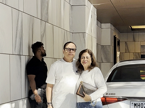 फिल्म प्रोड्यूसर पत्नी के साथ पैप्स को पोज देते हुए।