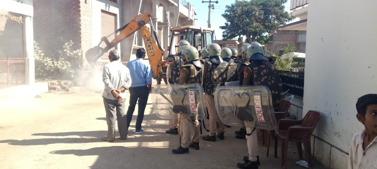 पुलिस जाब्ता की मौजूदगी में अतिक्रमण हटाते हुए जेसीबी