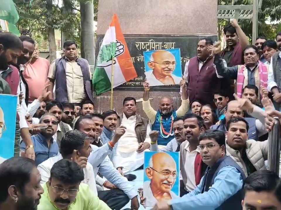 महात्मा गांधी की प्रतिमा के सामने बैठक प्रदर्शनकारी कांग्रेसी।