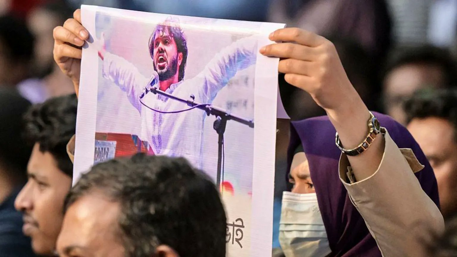 प्रदर्शन के दौरान हादी की तस्वीर दिखाती महिला।