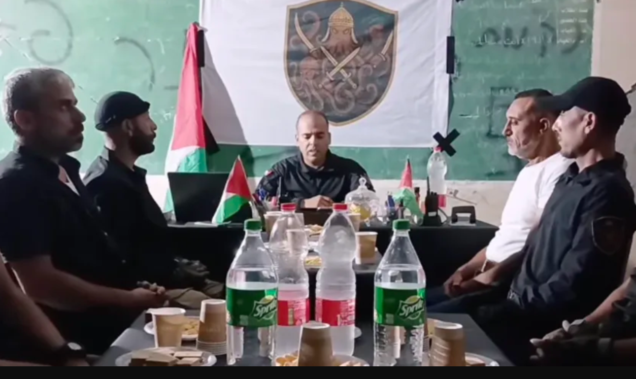 मिलिशिया ग्रुप पॉपुलर डिफेंस आर्मी के नेता रामी हलास एक बयान पढ़ते हुए।