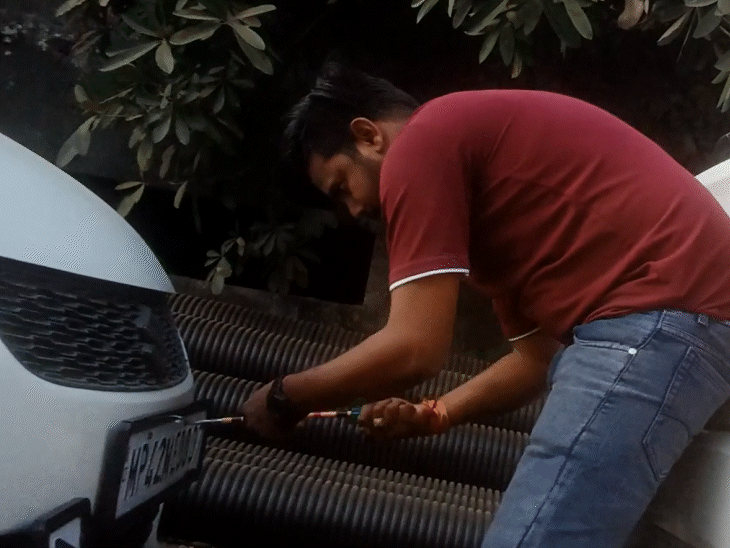 एंजेल ग्राफिक्स का ओनर राहुल साहू गाड़ी पर नंबर प्लेट लगाते हुए। उसने इसे आधे घंटे में बना दिया जबकि ये नंबर प्लेट बनने से एक हफ्ते से ज्यादा का समय लगता है।