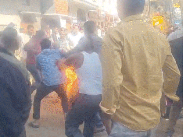 जब लोग आग बुझा रहे थे, वहां मौजूद पुलिसकर्मी दूर भाग रहे थे।