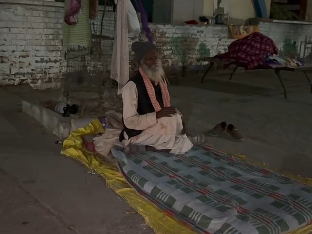 कड़ाके की ठंड में सड़क किनारे किसी तरह से रात गुजारता वृद्ध