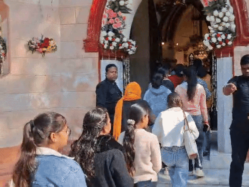 सेंट थॉमस चर्च में प्रार्थना के लाइन लगाकर जाते लोग।