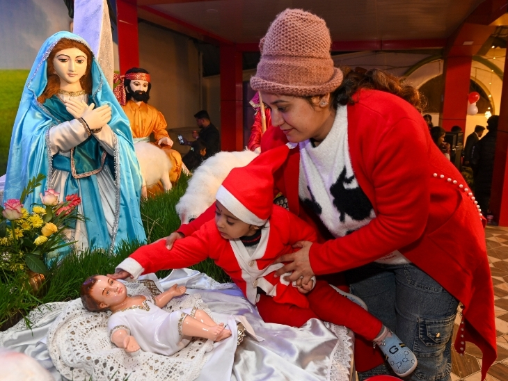 मध्य प्रदेश के जबलपुर में होली ट्रिनिटी चर्च में चरणी में लेटे बाल यीशू को दुलारता नजर आया।