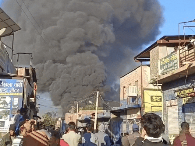 कबाड़ के गोदाम में आग लगने के बाद उठती धुएं की लपटें।