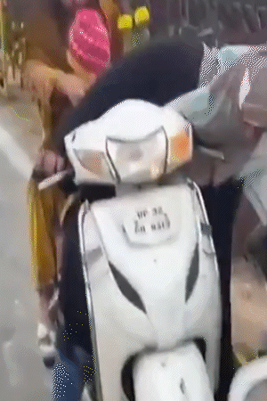 बुर्का पहने महिला की स्कूटी से आती है। जल्दी-जल्दी 2-3 गमले उठाती है और चली जाती है।