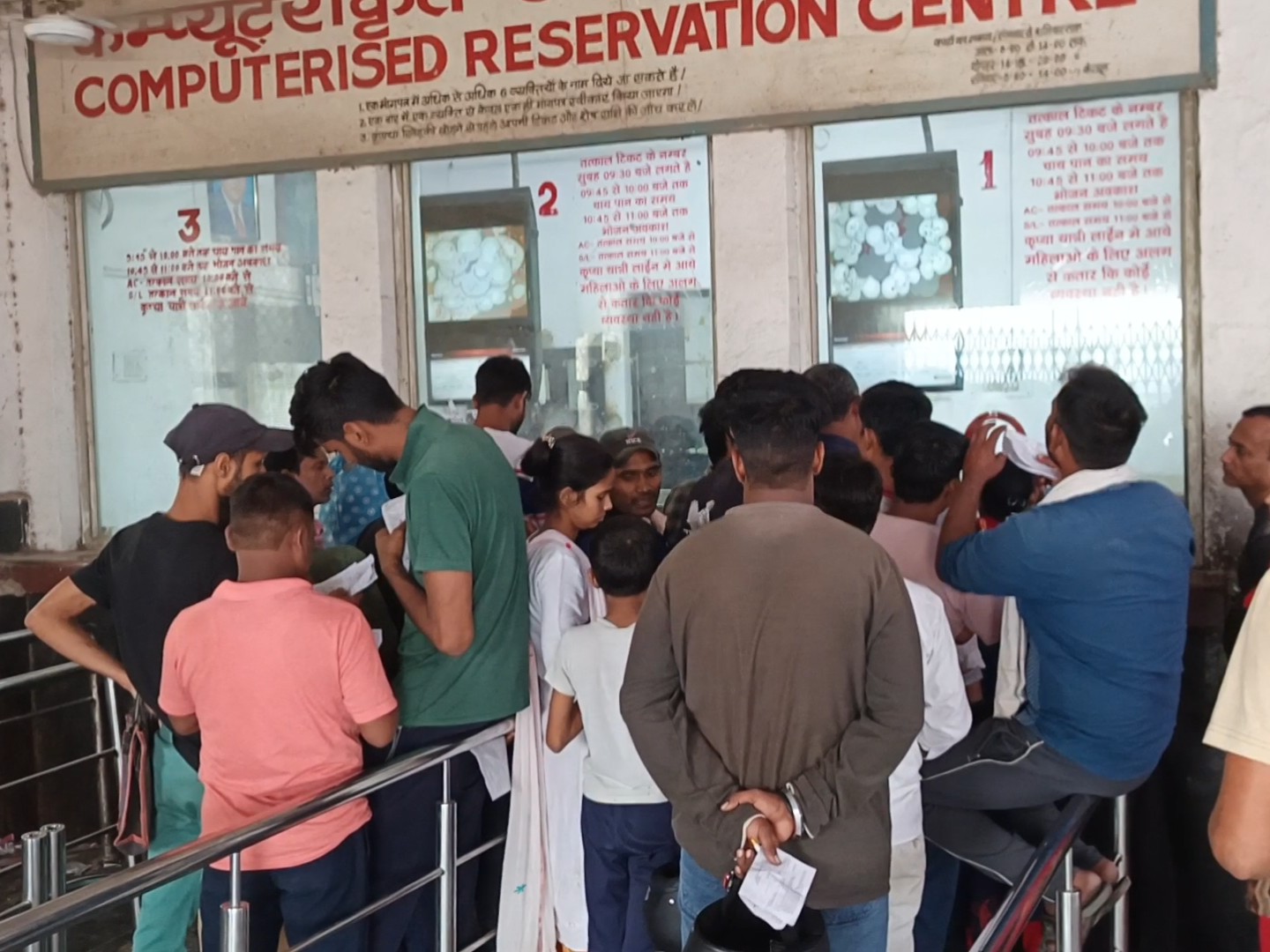 फरीदाबाद रेलवे स्टेशन पर टिकट लेने के लिए खड़े यात्री।