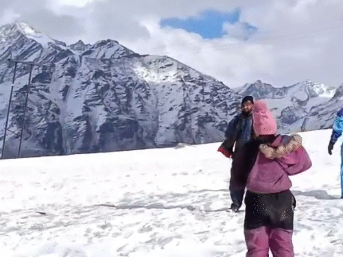 शिंकुला दर्रा में बर्फ के बीच मस्ती करते हुए टूरिस्ट।