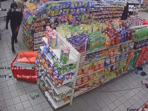 एक चोर अंदर घुसकर ATM मशीन से केबल बांधता है और बाहर आकर गाड़ी चलाने का इशारा करता है।