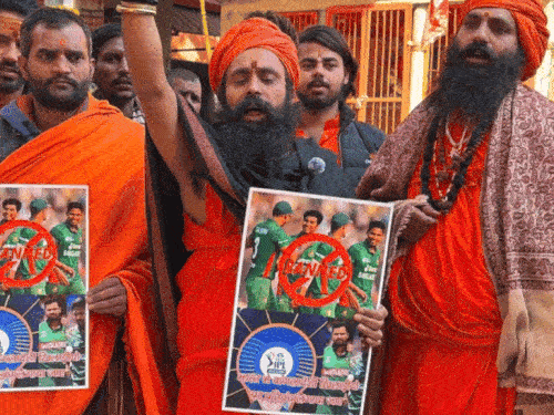 हाथ में बांग्लादेशी खिलाड़ियों का पोस्टर लेकर बैन करने की मांग करते संत।