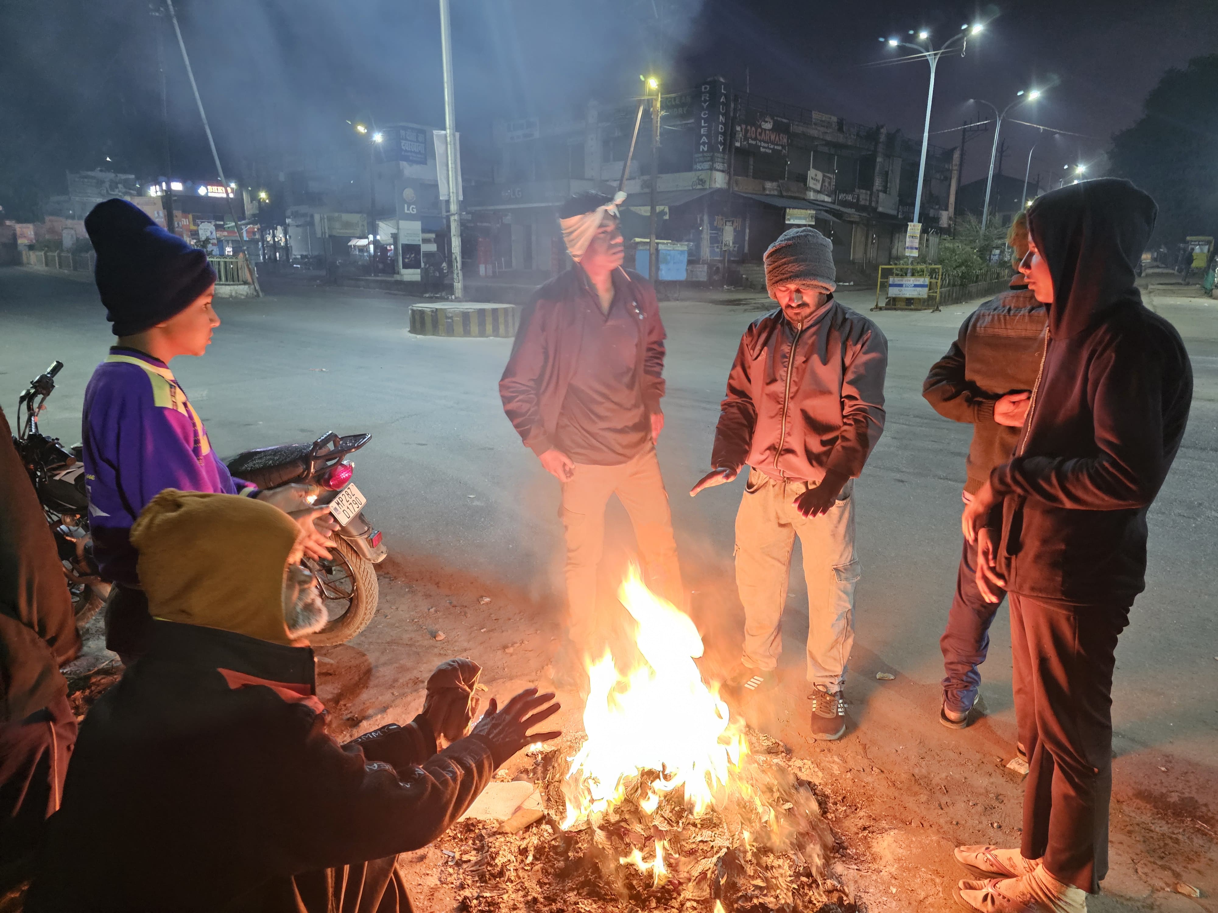 सुबह अलाव का सहारा लेते लोग