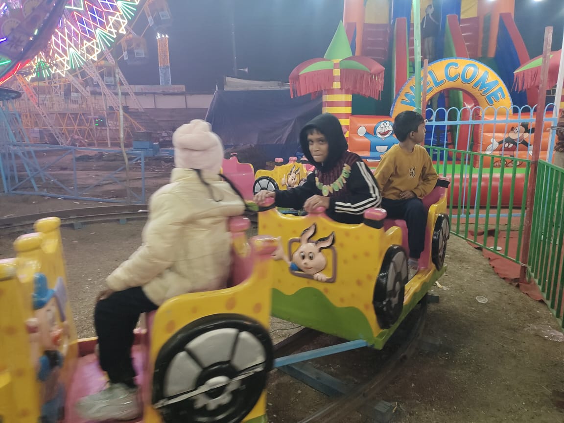 मेले में झूले पर घूमते नन्हे मुन्ने बच्चे