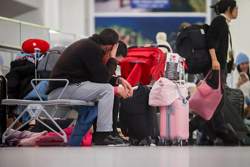 न्यूयॉर्क के जॉन एफ. कैनेडी एयरपोर्ट पर फ्लाइट देर होने पर इंतजार करते पैसेंजर।