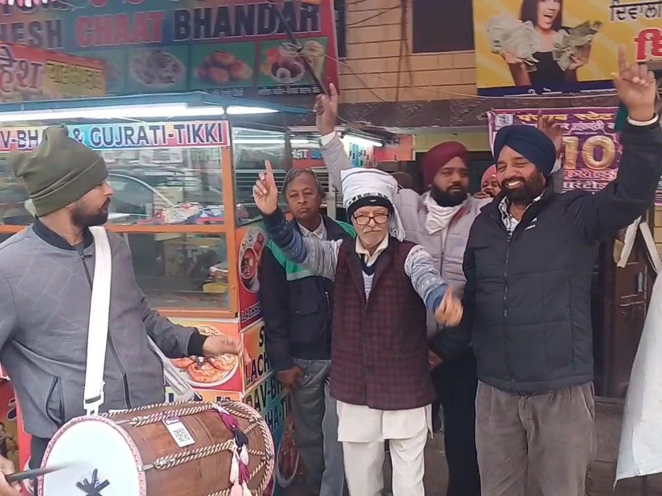 एक करोड़ की लॉटरी निकलने पर ढोल की थाप पर नाचते किसान और अन्य।