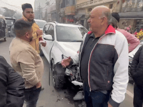 युवक के कार बैक करने से पीछे टकराई गाड़ी और उसके नुकसान के बारे में बताते लोग।