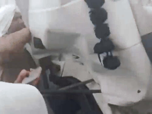 कंटेनर की खिड़की उखाड़ते राहगीर।