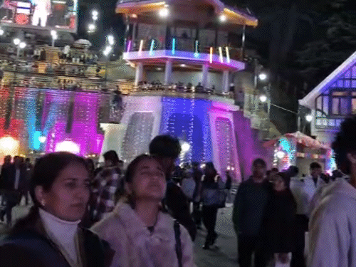 शिमला के रिज पर शाम के वक्त सुहावने मौसम का आनंद उठाते हुए टूरिस्ट।