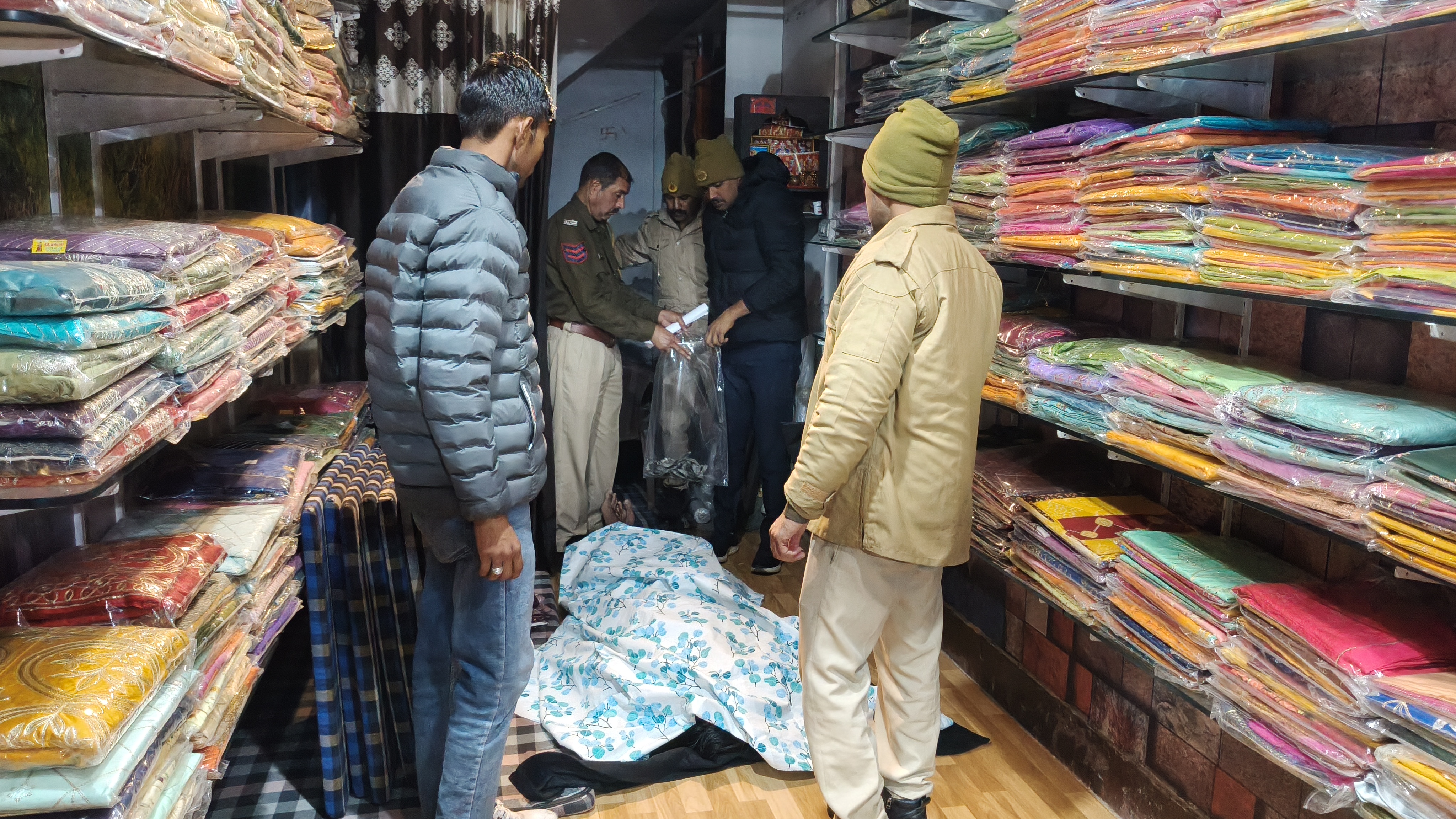 शव को फंदे से उतारने के बाद घटनास्थल का जायजा लेते जांच अधिकारी