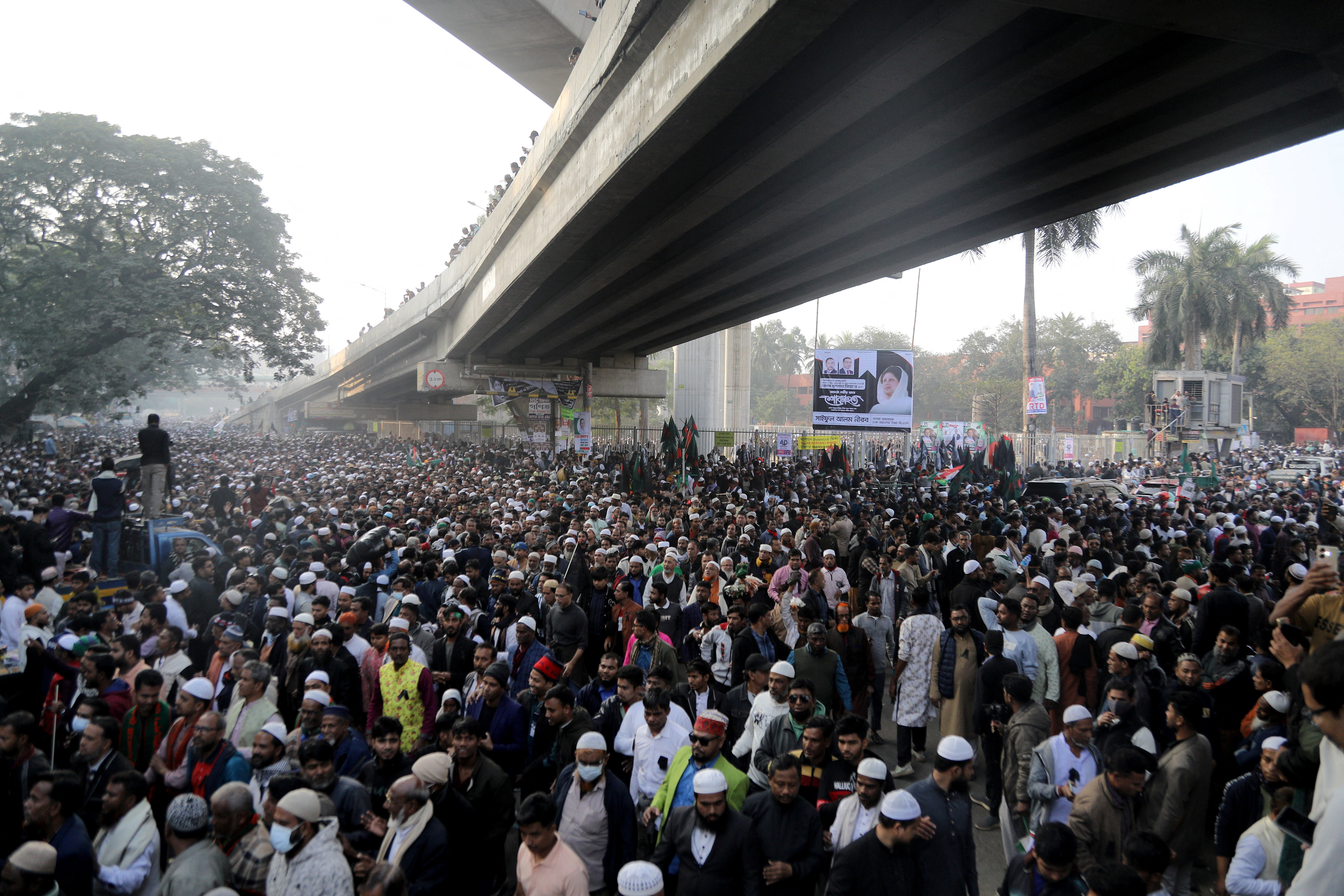 बांग्लादेश में संसद भवन के पास खालिदा जिया की नमाज-ए-जनाजा अदा करने के बाद वापस लौटते हुए लोग।