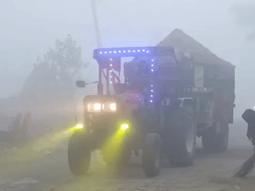 A tractor passing through dense fog in Kaithal