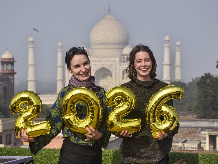 आगरा के ताजमहल के सामने विदेशी पर्यटक नए साल के स्वागत के लिए उत्सुक दिखे।