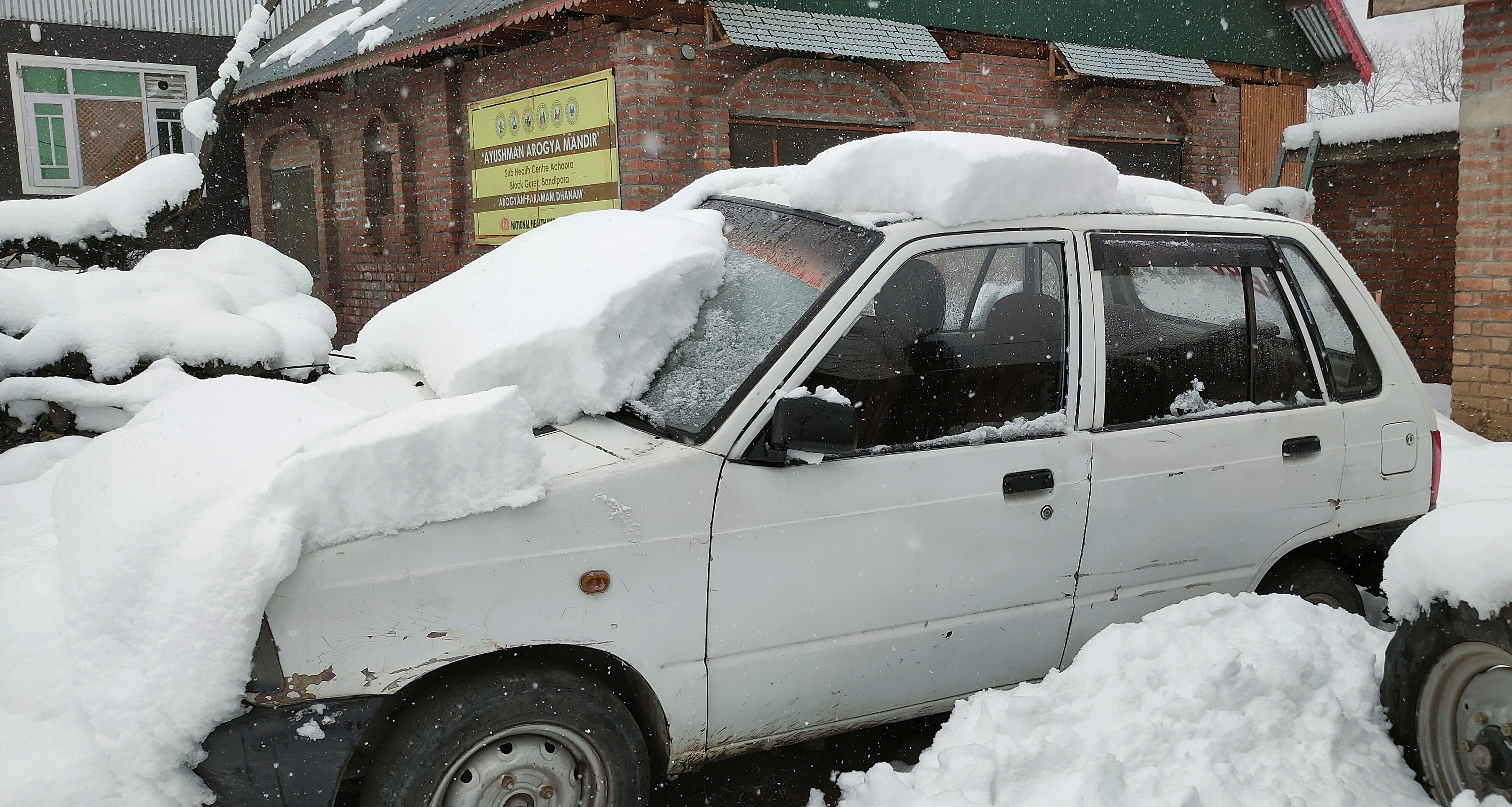 कश्मीर के बांदीपोरा में सड़क, मकानों और वाहनों पर बर्फ की मोटी परत जम गई।