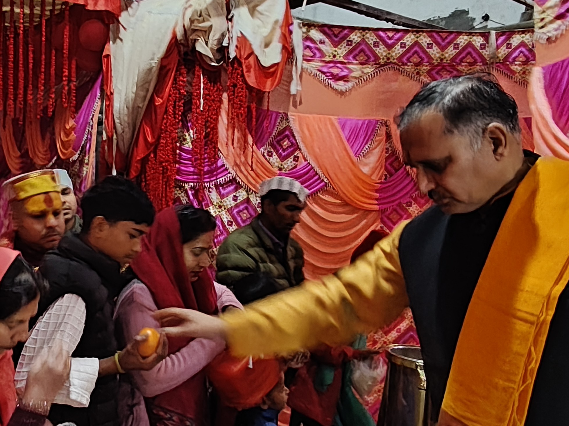 माता का भोग वितरित करते पुजारी।