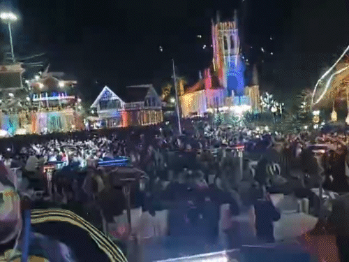 शिमला के रिज पर विंटर कार्निवल में नाचते हुए टूरिस्ट।