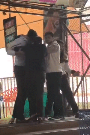 युवक और अन्य लोग दोनों को छुड़ाने की कोशिश कर रहे।