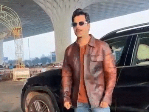 एयरपोर्ट पर कैमरे के सामने पोज देते हुए एक्टर वरुण धवन।