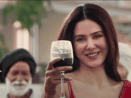 Sonam Bajwa filming a scene of a film with liquor and cigarette in her hand.