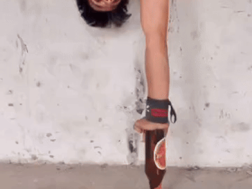 एक बोतल पर उल्टे होकर एक हाथ पर स्टंट करते हुए करण मलिक।