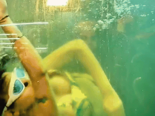 झांसी महोत्सव में जलपरी बनकर पानी में करतब दिखाती युवती।