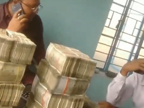 TMC नेता के सामने 500-500 के नोटों की गड्डियां रखी थीं। वे खुद फोन पर बात कर रहे थे।