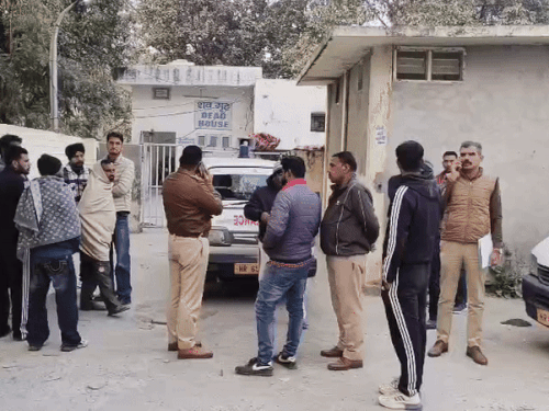 पोस्टमॉर्टम हाउस के बाहर खड़े मृतकों के परिजन और पुलिस।