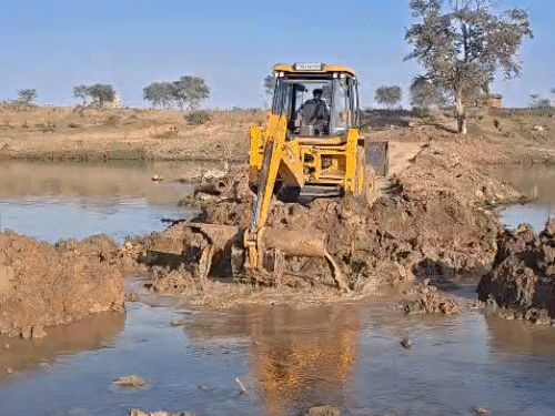 जेसीबी की मदद से अवैध पुल की मिट्टी हटाई गई।