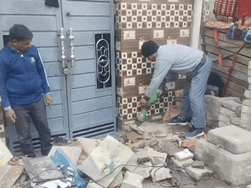 मकान को तोड़ने की कार्रवाई करते कर्मचारी।