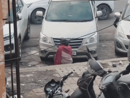 गाड़ी के पीछे बैठकर नशीला पदार्थ सूंघती लड़की।